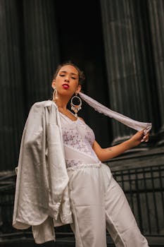 时尚女性在别致的户外环境中，摆出姿势，突出红唇和大胆耳环