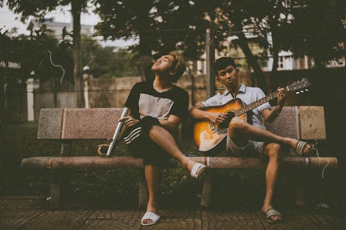 Photo of Man Playing Guitar Beside Another Man