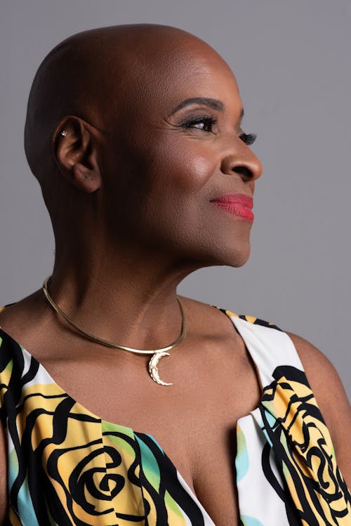 Studio Shot of a Bald Woman Wearing a Dress and Glamour Makeup 