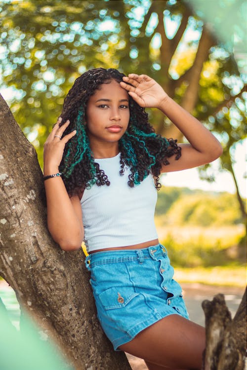 A Girl in a Crop Top and Denim Skirt Standing against a Tree 