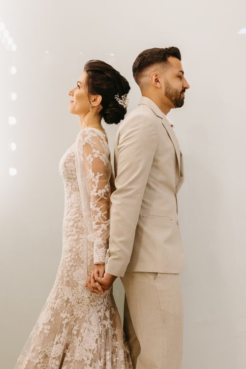 Free Stylish wedding couple posing back-to-back in elegant attire, capturing a modern and romantic moment. Stock Photo
