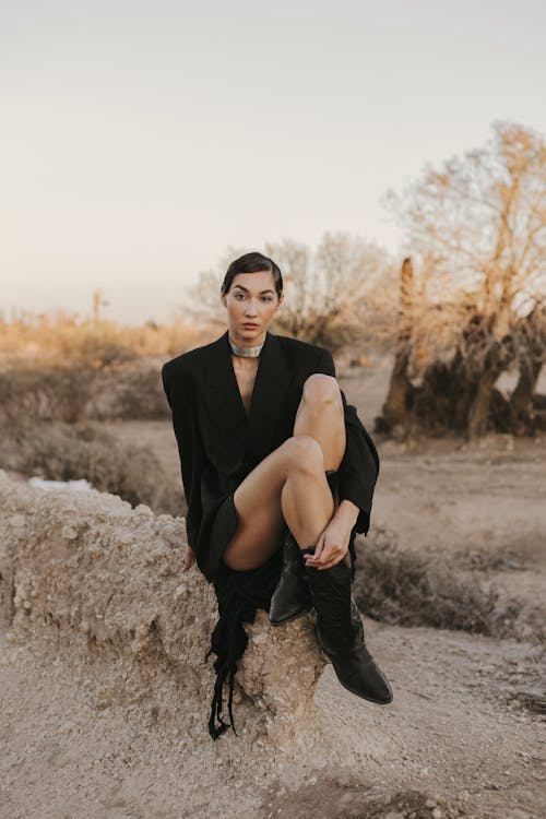 Elegant Woman in Black Sitting on Rock