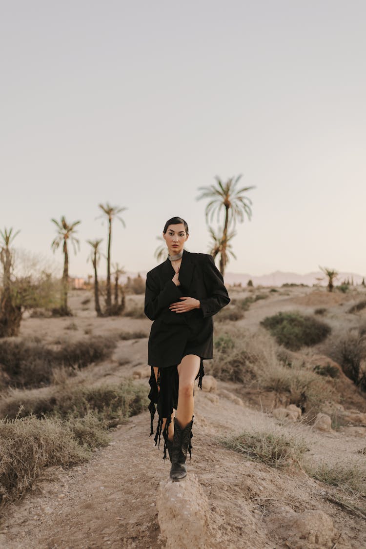 Woman In Black Elegant Clothes Posing On Desert