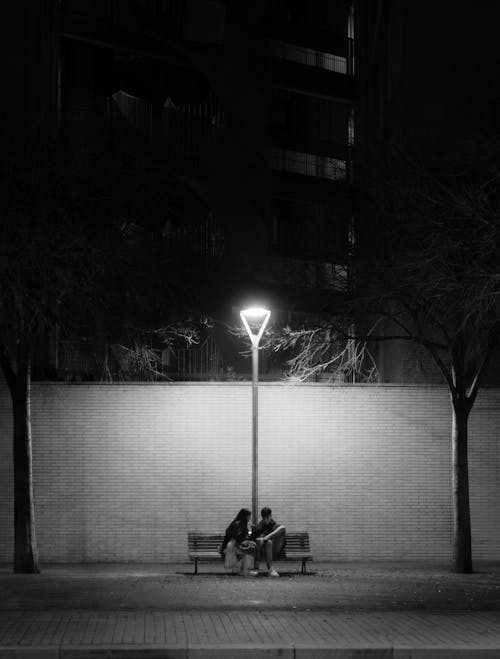 Couple Sitting on Bench at Park at Night