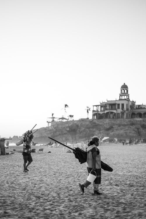 Woman and Man Walking on Beach in Black and White