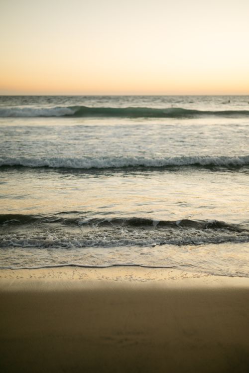 Free A serene beach at golden hour with gentle waves and a pastel sky. Stock Photo