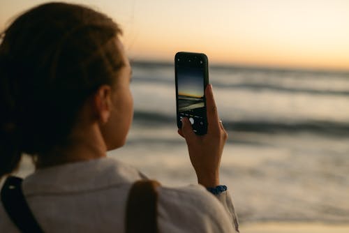 Woman Recording Sea at Dawn