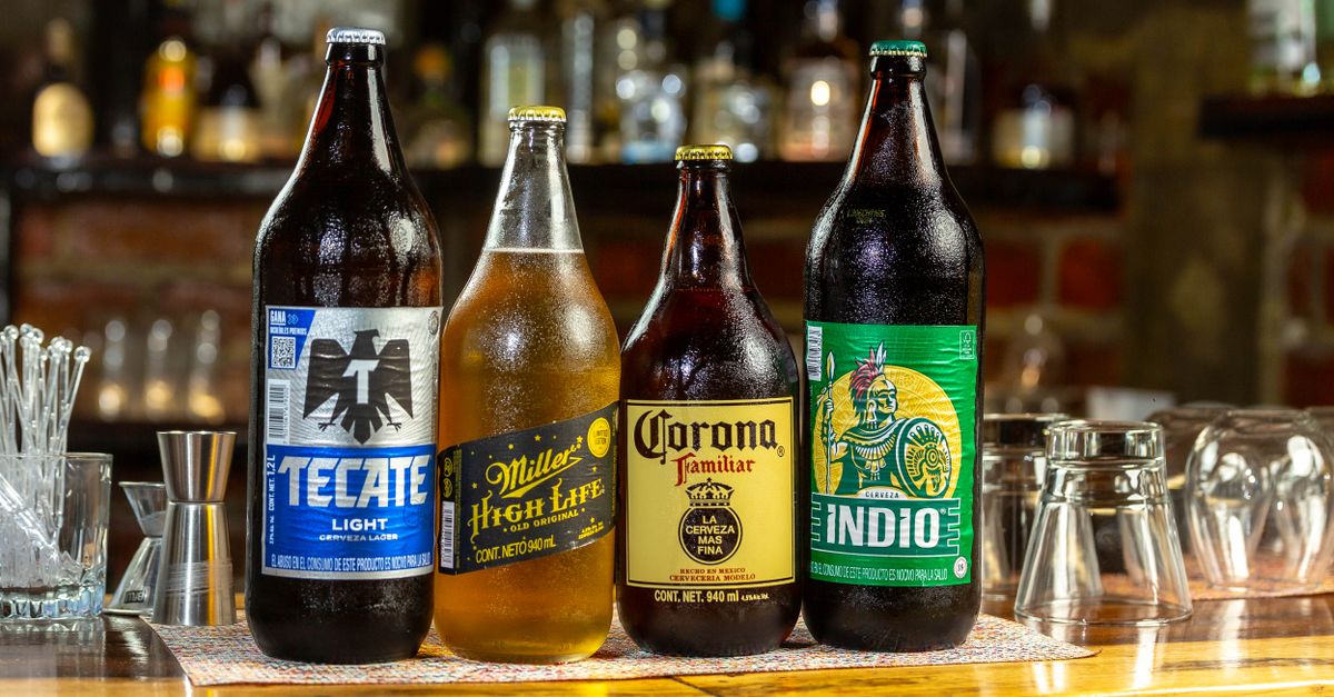 Four beer bottles including Tecate, Miller, Corona, and Indio on a bar counter.