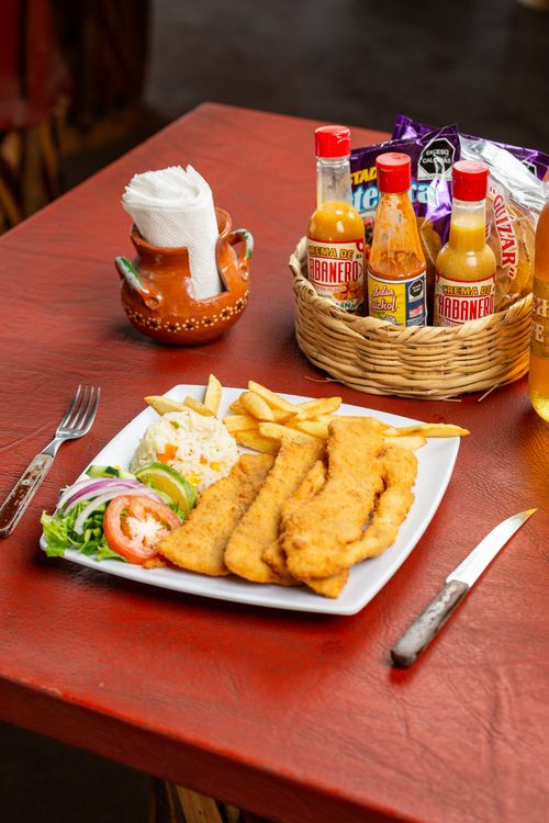 Free Fried fish served with fries and salad, a tantalizing lunch setup. Stock Photo