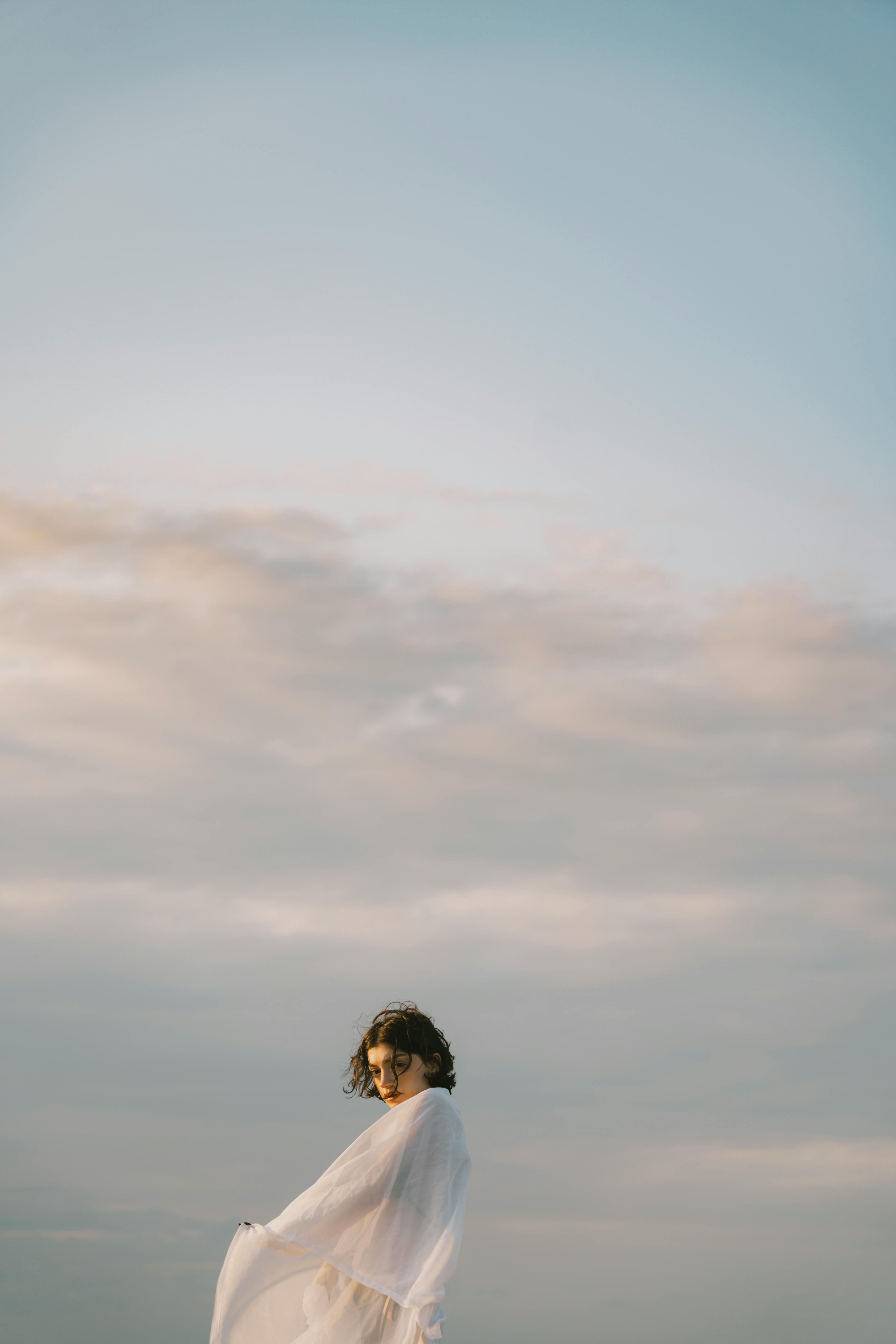 a woman in a white dress standing on a beach