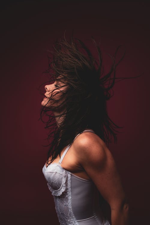 Brunette Woman in White Bodysuit Posing in Studio