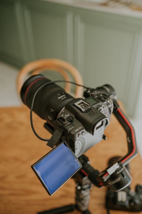 Free DSLR camera mounted on tripod with open screen indoors, perfect for videography setup visuals. Stock Photo