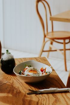 A warm, inviting breakfast setting with a sunny side up egg bowl in a cozy restaurant.