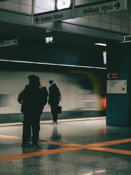 Free A person standing in a subway station with a train coming Stock Photo