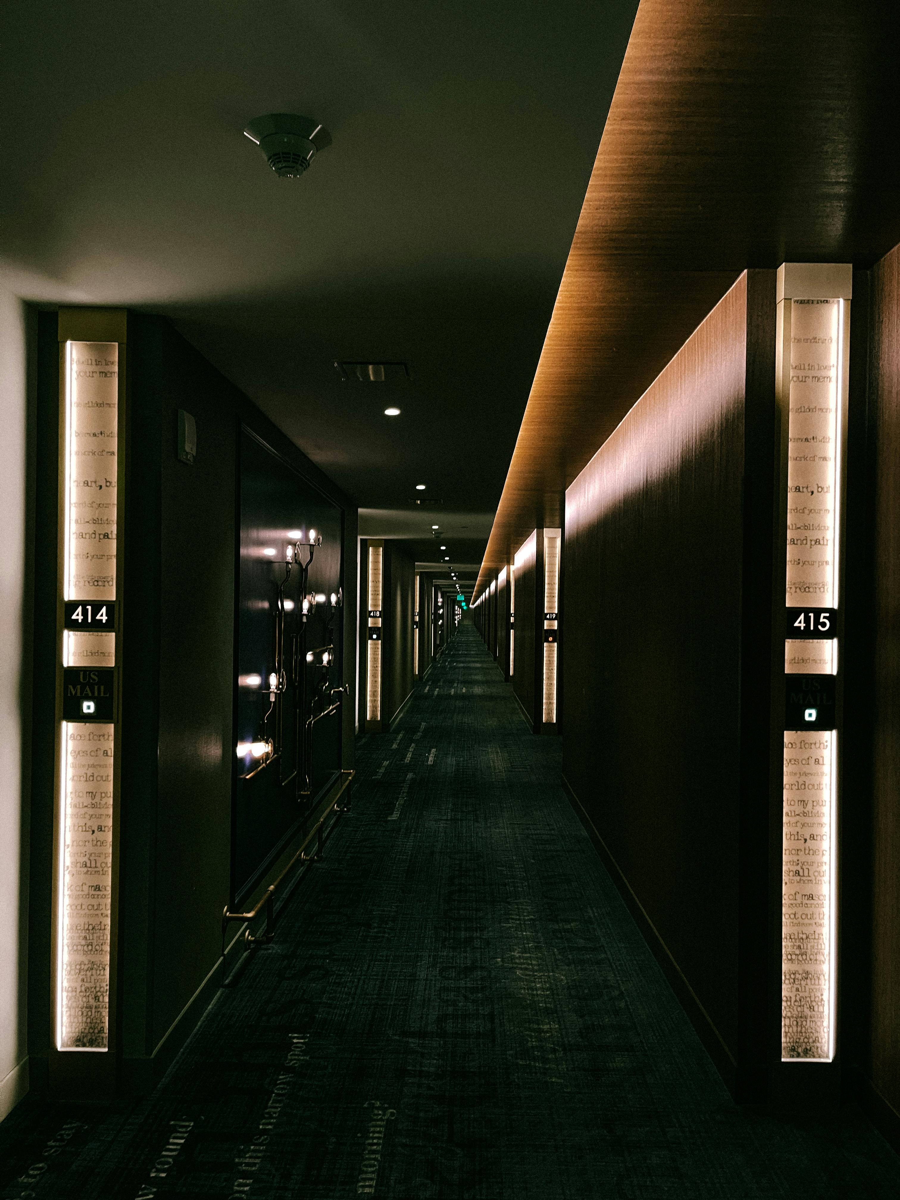 A sleek, dimly lit hotel hallway with modern design elements at night.