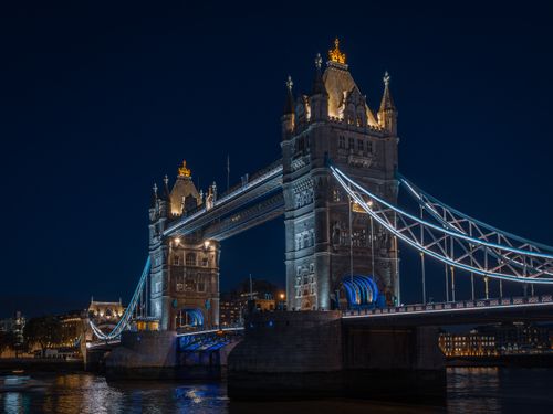 Free Stunning night view of London's Tower Bridge, illuminated against the dark sky, showcasing its architectural beauty. Stock Photo