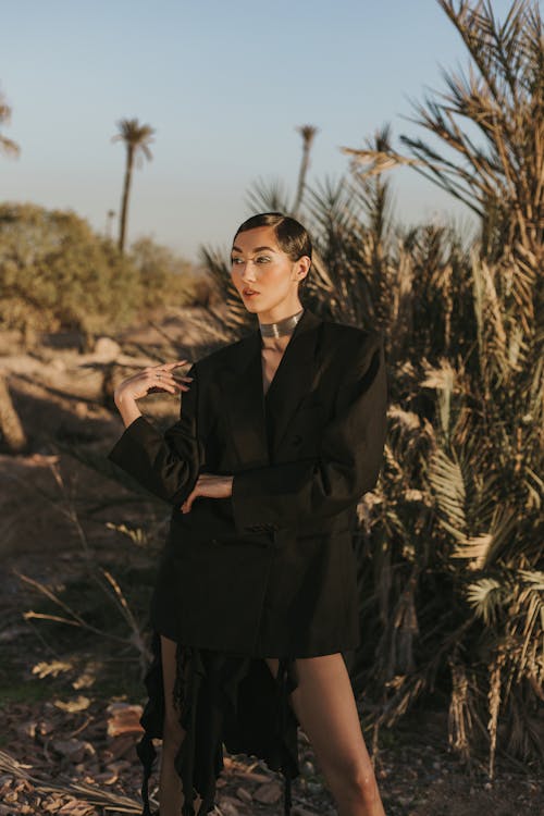 Free Woman in Elegant Clothes Standing against Palm Tree Stock Photo