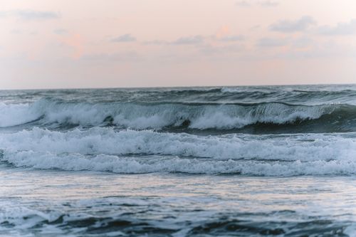 Free Captivating waves crash on Pulukan Beach at sunset, Bali, Indonesia. Stock Photo