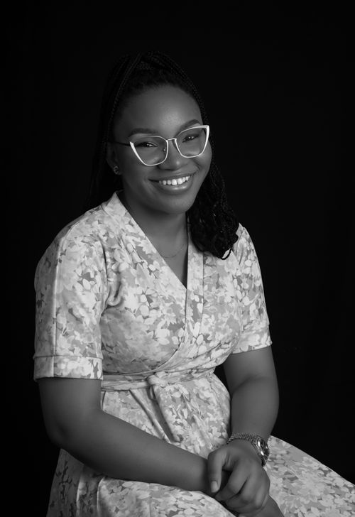 Free Charming portrait of a young woman smiling in a floral dress with eyeglasses. Stock Photo