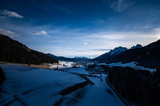 A stunning winter landscape showcasing snow-covered mountains and valleys under a dramatic sky.