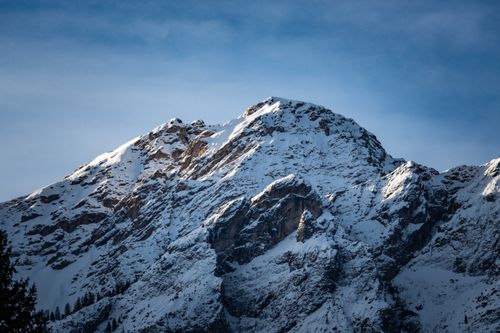 Free A stunning view of a snowcapped mountain peak under a clear blue sky, representing winter's beauty. Stock Photo