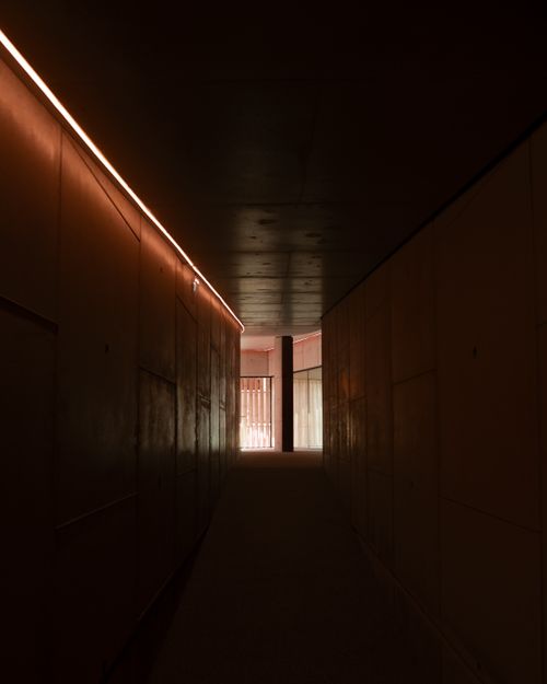 Free A dark, empty tunnel illuminated by soft ambient lines, creating mysterious shadows. Stock Photo
