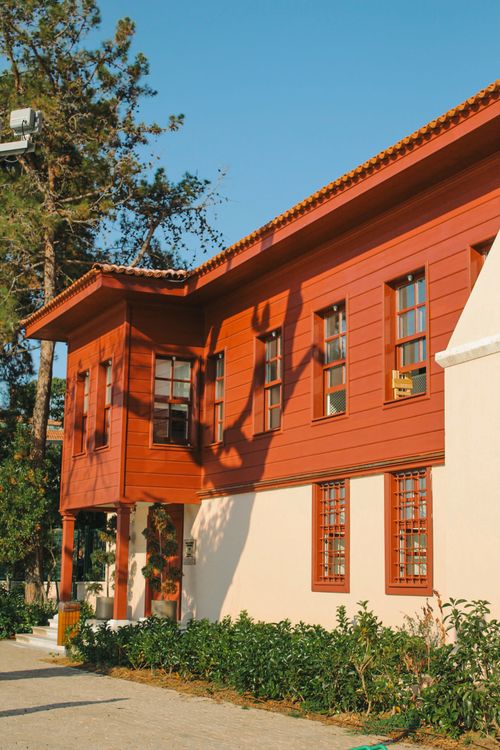 Free Charming red wooden house in Istanbul, Türkiye, under bright sunlight with lush greenery Stock Photo