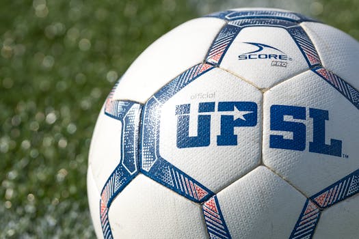 Detailed shot of a UPSL soccer ball on green grass, perfect for sports themes.
