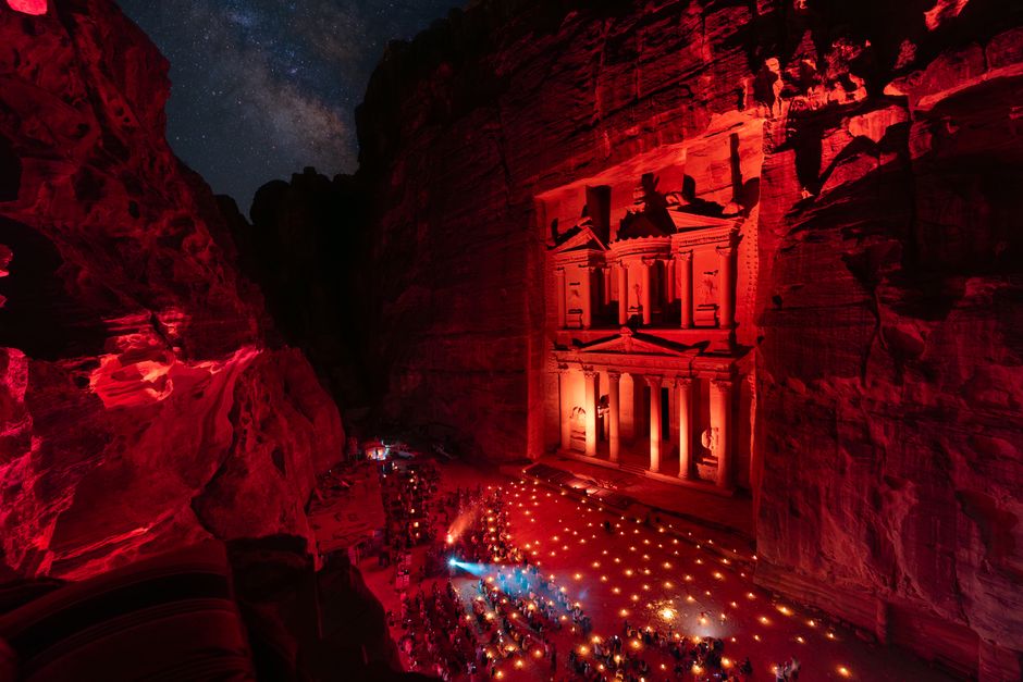 Petra's iconic Treasury illuminated with red lights during an evening performance, Wadi Musa, Jordan.
