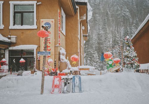 Snow-covered village with lanterns and decorations in Harbin, China.