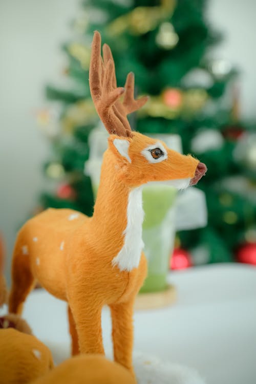 Close-up of a Reindeer Cuddly Toy on the Background of a Christmas Tree