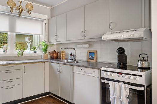Home Makers – 10 najczęstszych pytań przed pierwszą współpracą 2 Clean and stylish modern kitchen with white cabinets and stainless steel appliances.
