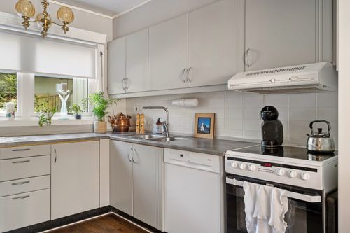 Free Clean and stylish modern kitchen with white cabinets and stainless steel appliances. Stock Photo