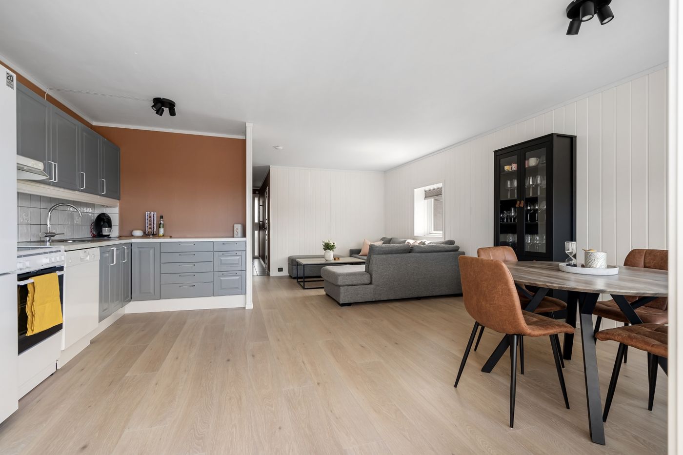 Sala integrada à cozinha com móveis, eletrodomésticos e decoração