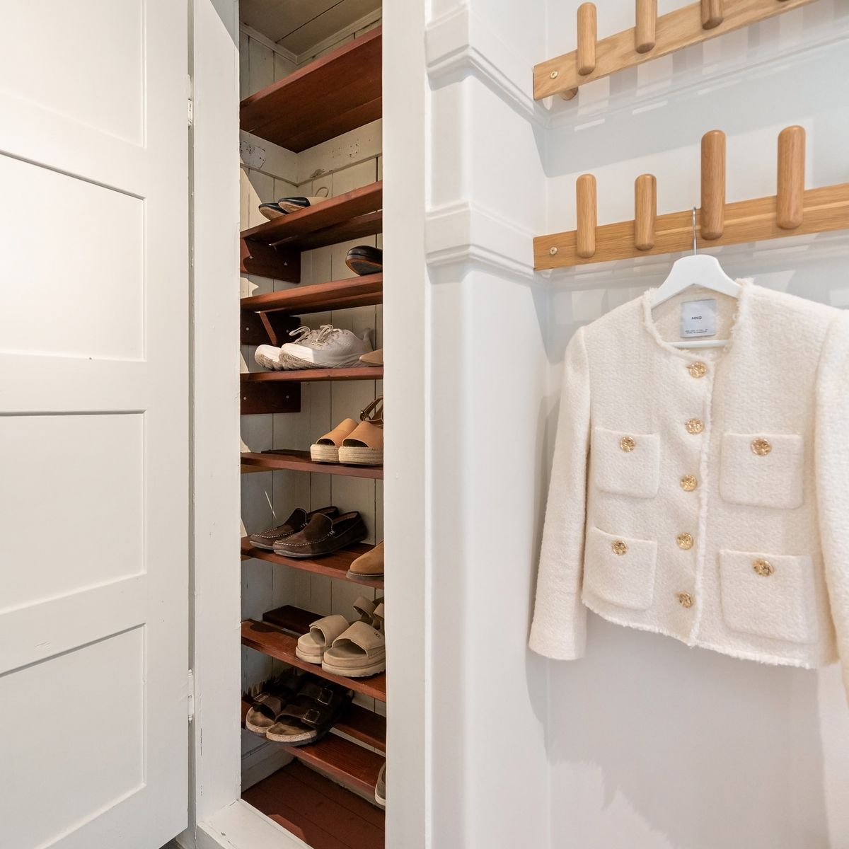 Guarda-roupa aberto com sapatos organizados em prateleiras claras