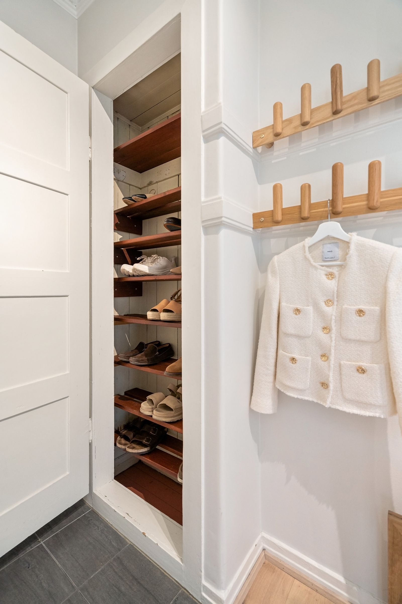 An organized closet with shoes stored neatly alongside hanging clothes