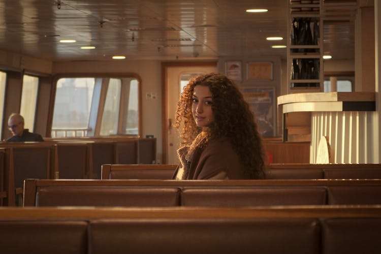 Young Woman Sitting In A Ferry Looking Over Her Shoulder