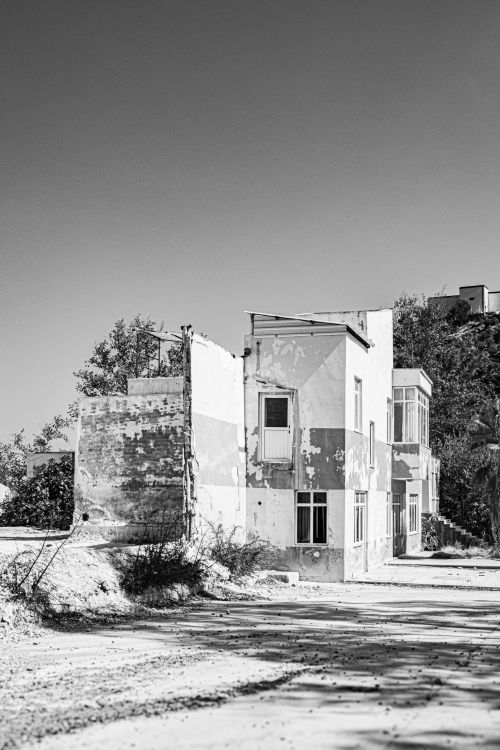 Free Monochrome image of an old, damaged residential building with peeling paint and weathered walls. Stock Photo
