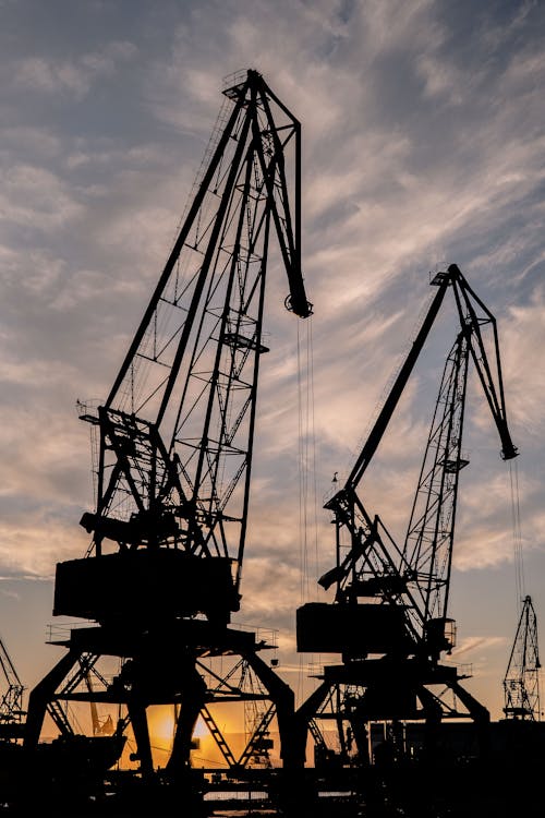 Silhouettes of Harbor Cranes at Sunset