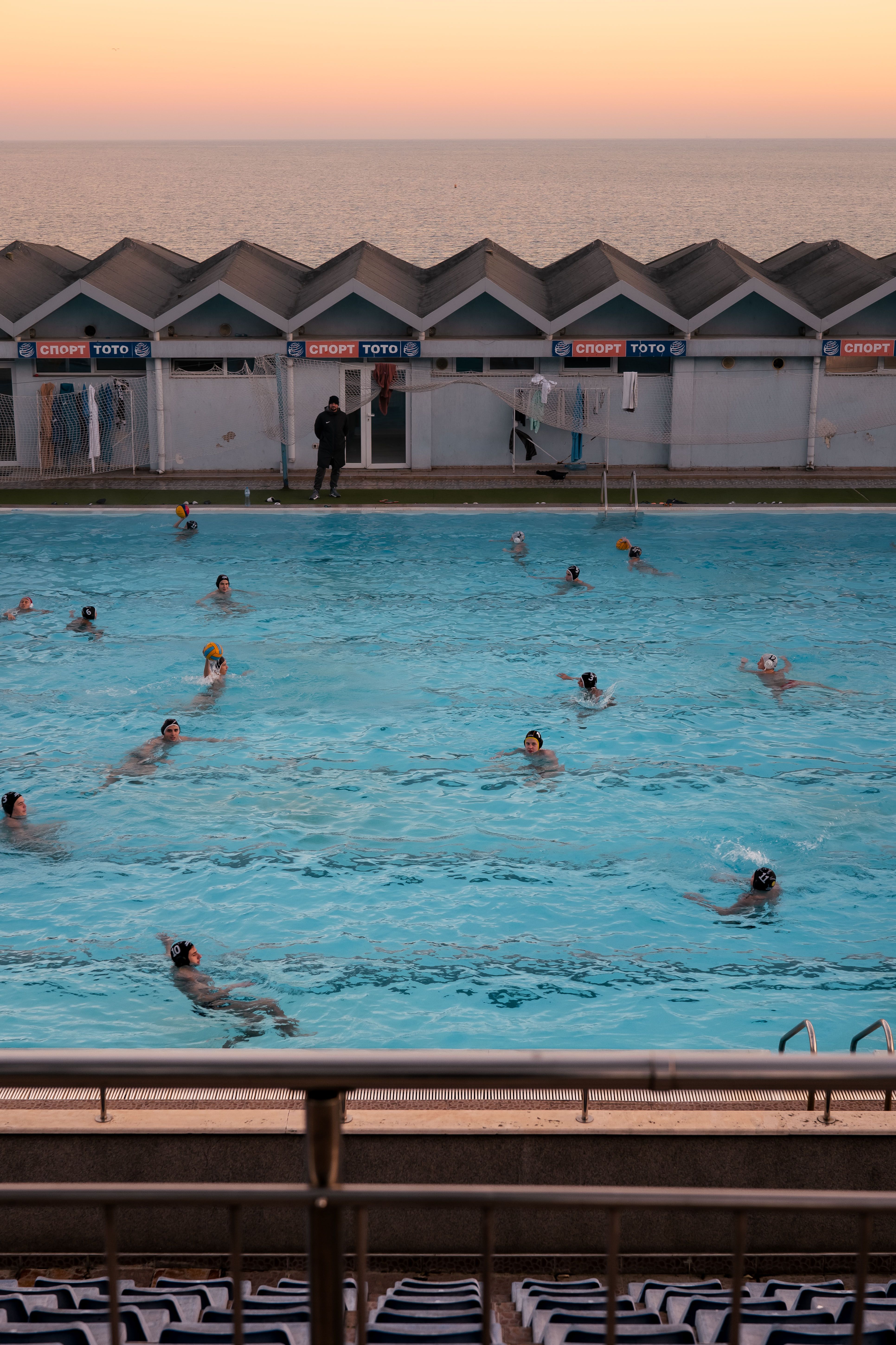 People Swimming in a Pool by the Sea at Sunset · Free Stock Photo