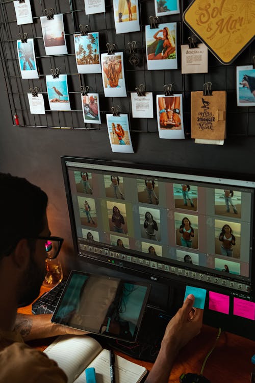 Free A man is working on a computer with a photo album Stock Photo