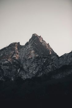 A striking snow-capped mountain peak in dusky light, showcasing nature's rough beauty.