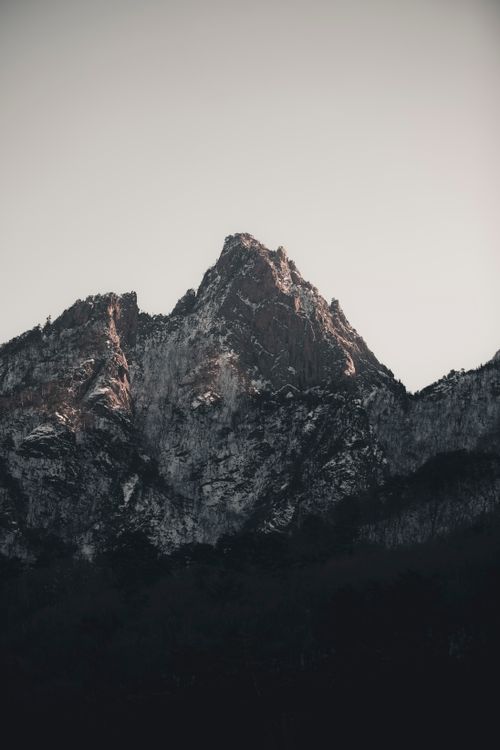 Free A striking snow-capped mountain peak in dusky light, showcasing nature's rough beauty. Stock Photo