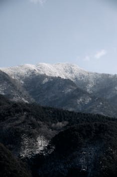Serene snowcapped mountain scene under a clear sky, perfect for winter landscapes.