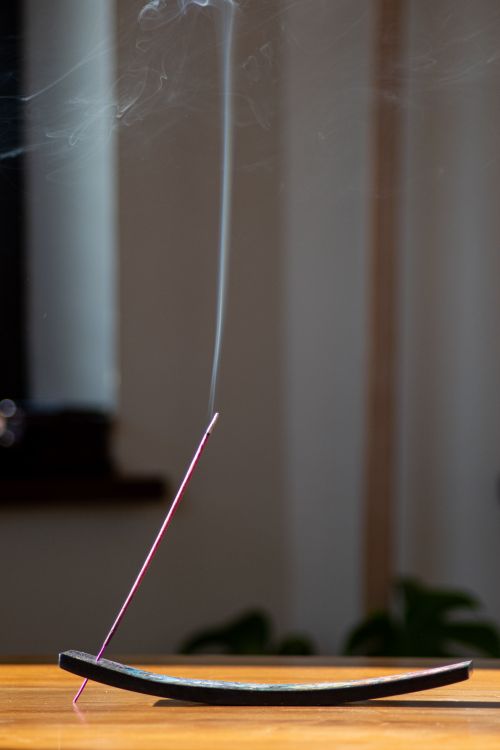 Free A tranquil scene featuring a smoking incense stick on a stand, perfect for relaxation imagery. Stock Photo