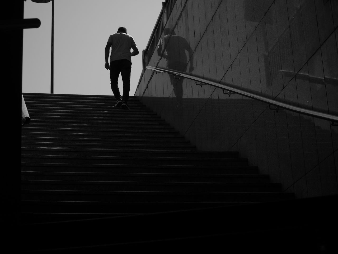 A person climbing stairs, photographed in black and white