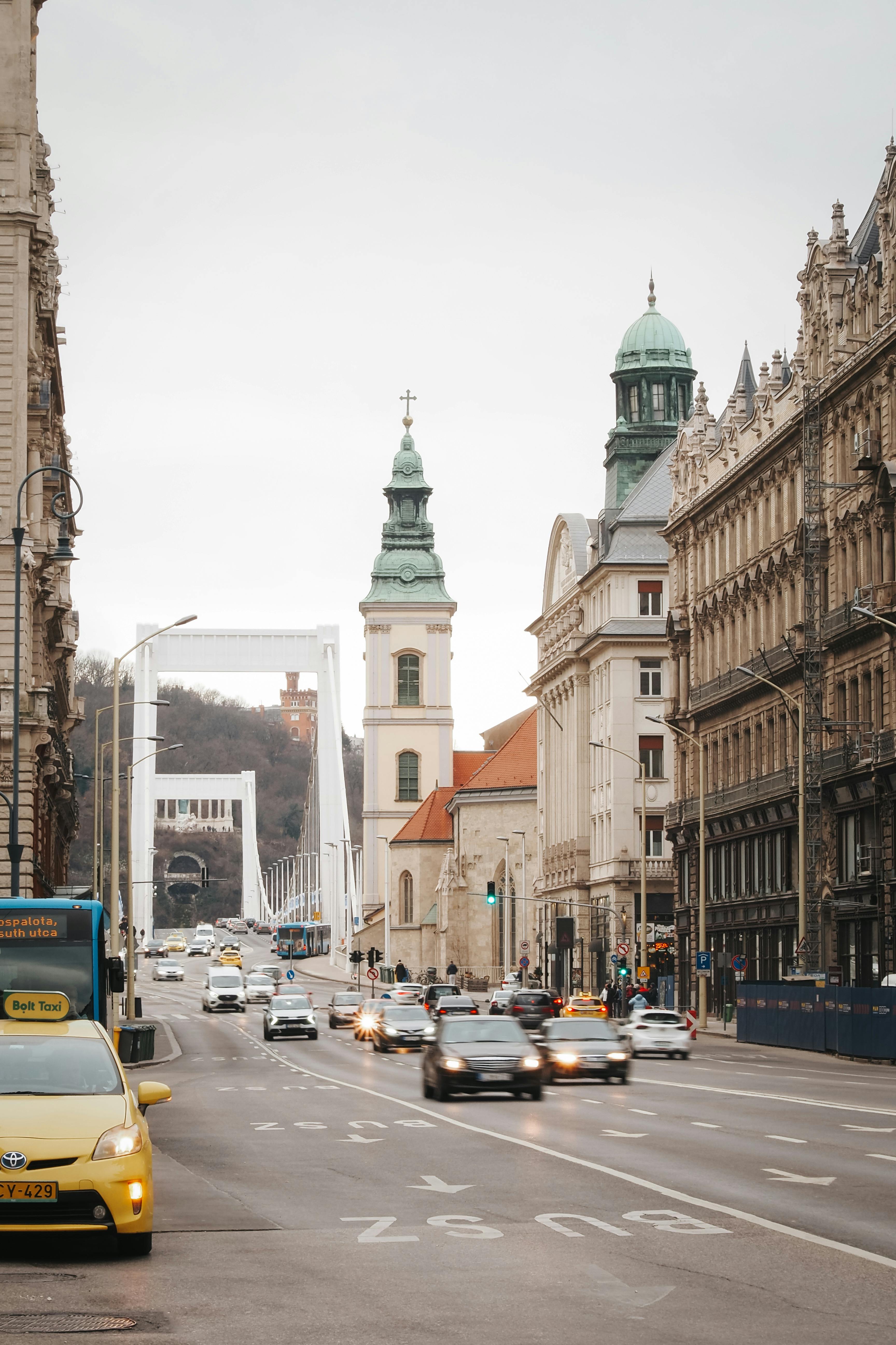 View of a busy street in Budapest with cars and the iconic Elisabeth Bridge in the background.