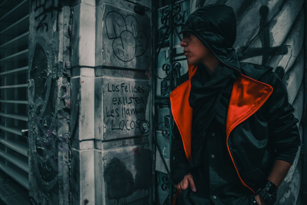 moody portrait of a man in urban setting showcasing street art and fas