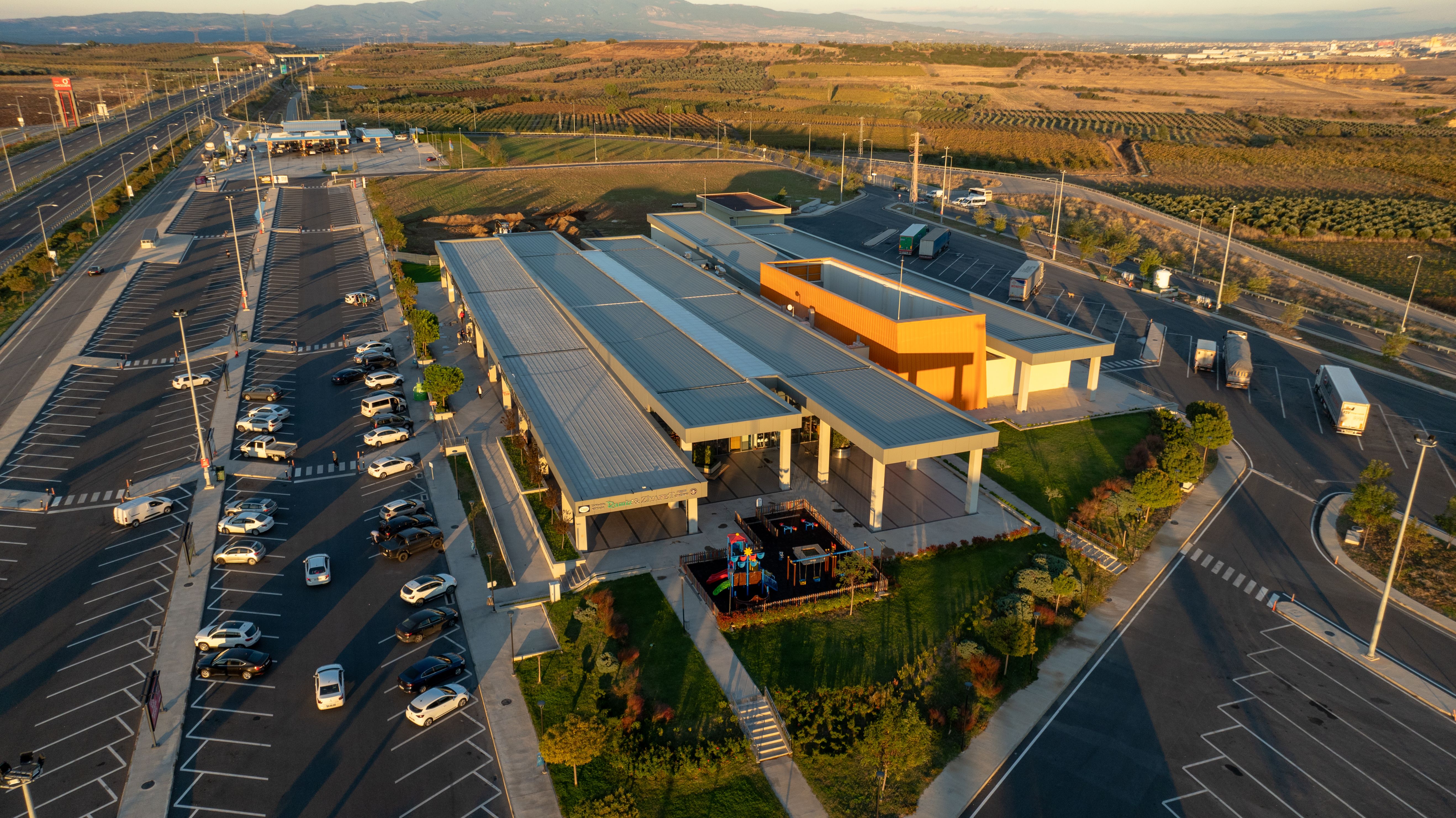 A scenic aerial view of a highway rest area in Şehzadeler, Manisa, Türkiye at sunset.