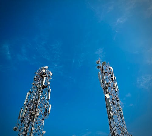Two cell towers against a blue sky